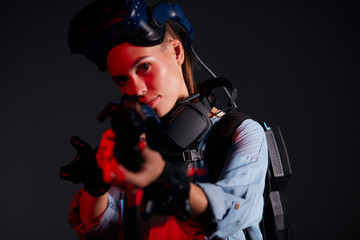 Beautiful caucasian girl with weapon of virtual reality game, isolated over black background