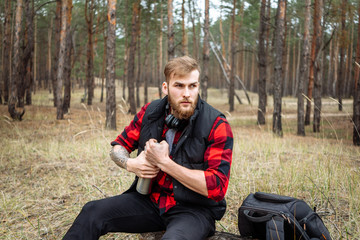 Naklejka na ściany i meble Man resting in the forest and drinking tea from the thermos.