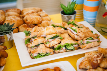 buffet for celebration birthday food on plates, home made sandwiches and decorations