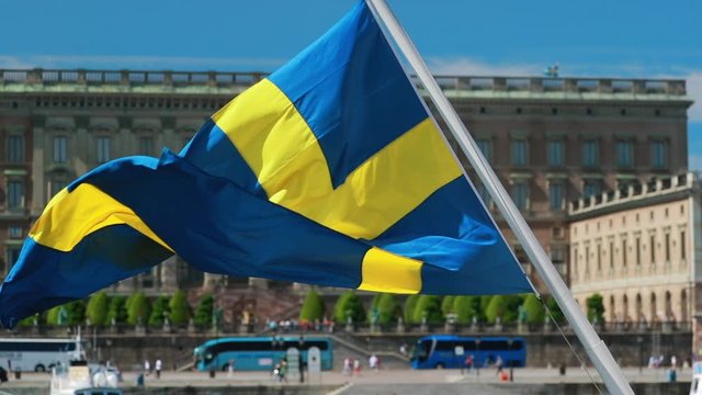 Stockholm, Sweden. Waving Swedish Flag In Stockholm Street