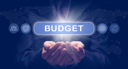 Businessmans cupped hands holding a Budget business concept on a computerised display.