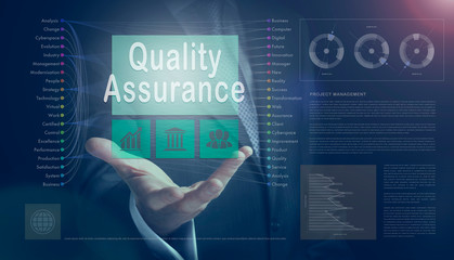 Businessman outreached hand holding a Quality Assurance business concept on a computerised screen display.