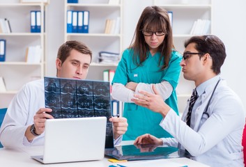 Three doctors discussing scan results of x-ray image