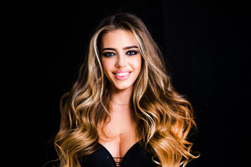 Beautiful woman with long smooth shiny straight hair. Blond woman with long curly beautiful hair. Close up beauty portrait of a laughing beautiful woman on black background.