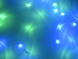 Background for Christmas, with delicate and soft tones. Fuzzy. The predominant colors are blue, green and white. The atmosphere of magic.Christmas lights without sharpness (not focus).