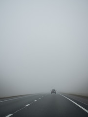 heavy fog on the road. one car in the fog