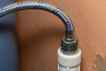 Old threaded connection of plastic pipe and hose. Concept: plumbing repair, care and maintenance of...