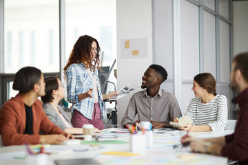 Portrait of creative business team smiling cheerfully while planning project during meeting in...