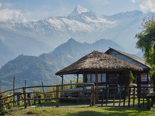Veranda with a thatched roof near a small cafe on the background of rice terraces and snow-capped peaks of the Himalayas