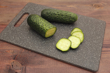 Chopped cucumber on cutting board on a wooden table