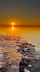 Panorama of beautiful sunset in Chieming. Ice in front of sunset. Chiemsee