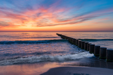 Baltic sea seascape at sunset, Poland, wooden breakwater and waves - obrazy, fototapety, plakaty