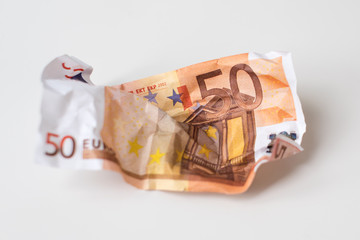 Crumpled euro money. European currency bills of 50 euros on white background. Selective focus. Money value, international, strong currency, inflation, waste