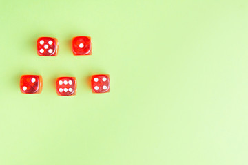 Red dice lying on a green background. from above. copy space