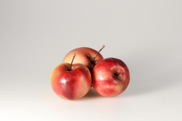 ripe beautiful apples and fruits lie on a gray background, in the snow, with a Christmas ball, with a candle, notebook, berries, snowman, garland, iris, rose hips