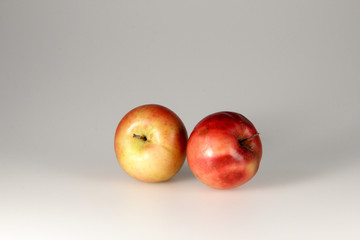 ripe beautiful apples and fruits lie on a gray background, in the snow, with a Christmas ball, with a candle, notebook, berries, snowman, garland, iris, rose hips