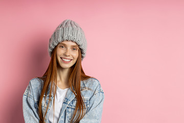 Portrait of excited young woman dressed denim jacket and knitted hat