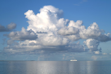 Naklejka na ściany i meble Kreuzfahrtschiff am Horizont verlässt Bremerhaven über die Nordsee und blauer Himmel mit weißen Wolken - Stockfoto