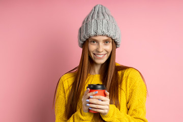 Redhead woman holding disposable cup of coffee