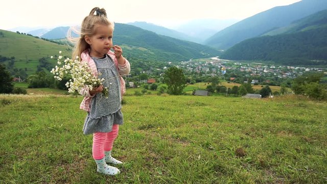 Girl kid staning with flowers and eating some snacks