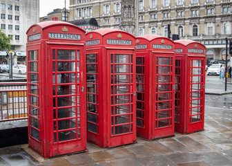 Fototapeta na wymiar four (4)red telephone boxes in London in a row