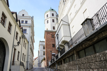 Narrow street between old houses and the Ducal Castle in Szczecin, Poland, former seat of the dukes of Pomerania-Stettin, blue sky © Maren Winter