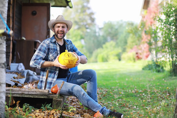 Autumn traditions and preparations for the holiday Halloween. A house in nature, a lamp made of pumpkins is cutting out at the table.