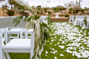 wedding aisle with greenery and white petals 