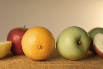 Oranges and apples on wooden table, close-up