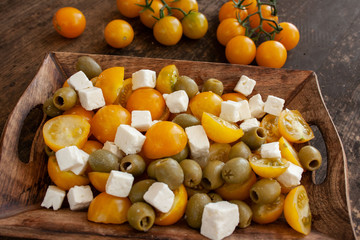 Salad of yellow cherry tomatoes with feta cheese and green olives