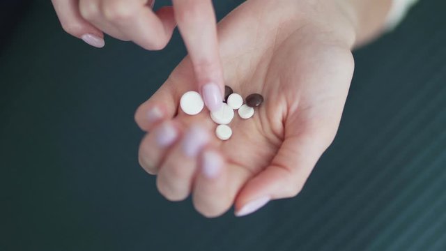 Organic and natural medicines. Pills in the hand of a female young palm. Ginseng, calcium, vitamins and minerals in the hand