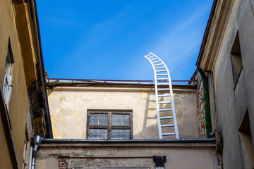 Wooden ladder into the sky. On the roof of an old house.