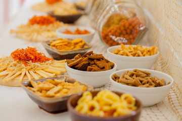 A lots of salty snacks on a table, many cheese and crackers on the table with snacks