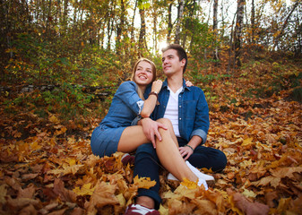 Loving happy young couple in forest park in autumn on nature at sunset background