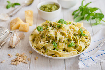 Large portion of noodles with fresh basil pesto and pine nuts