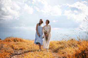 Two girls in dresses in autumn field