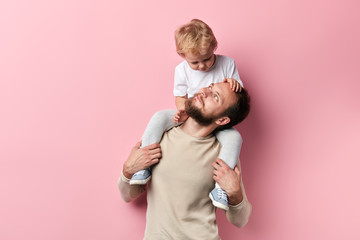 single parebt family. close up photo, isolated pink background, rlation between father and son - obrazy, fototapety, plakaty