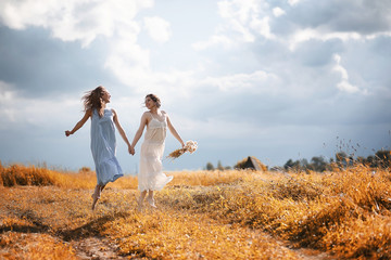 Two girls in dresses in autumn field