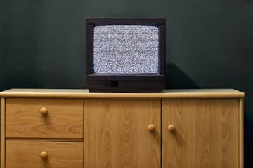 Small old TV set with no signal noise in a dim room