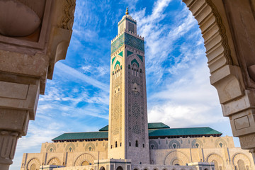 View of Hassan II mosque tower against blue sky - The Hassan II Mosque or Grande Mosquée Hassan II...