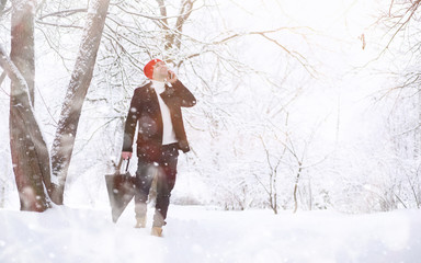 A man on a walk in the park. Young man with in the winter snowfall.