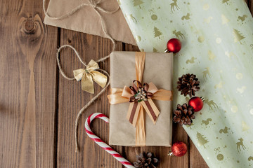 Christmas background with Christmas cones and toys, fir branches, giftboxes and decorations on a wooden table background