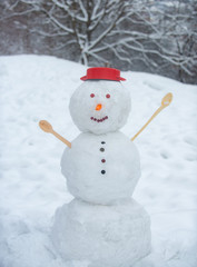 Winter scene with snowman cook on white snow background. Greeting snowman cook. Funny snowmen cooking. Snowman on a background snow-covered fir branches. Snowman and snow day.