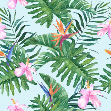 Tropical watercolor pattern with exotic flowers and leaves on a blue background.