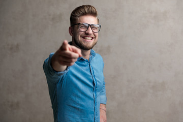 Happy casual man pointing forward and laughing