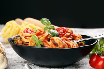 tagliatelle pasta with tomato sauce parmesan basil on rustic background
