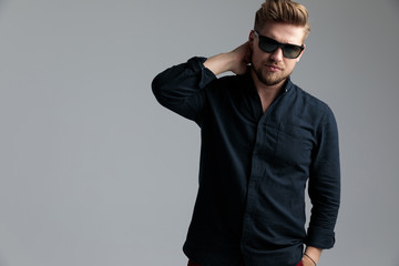 Confident fashion man holding his hand behind his neck
