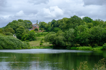 Pond and traditional house near the Admissions Hut into  Lyme Park, Disley in Cheshire, UK