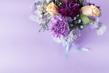 A spring gentle bouquet of mixed flowers on a purple background. First meeting bouquet or 8 of march concept.