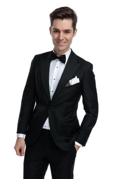 young modern man in tuxedo smiling on white background